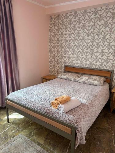a dog laying on a bed in a bedroom at Rob Guest House in Garni