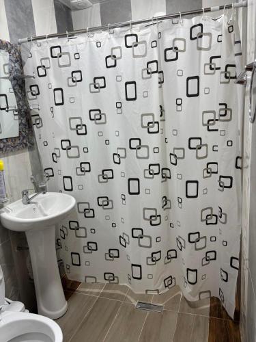 a bathroom with a shower curtain and a sink at Rob Guest House in Garni