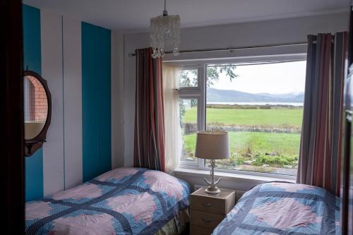 a bedroom with two beds and a window with a view at Bella Vista in Carlingford