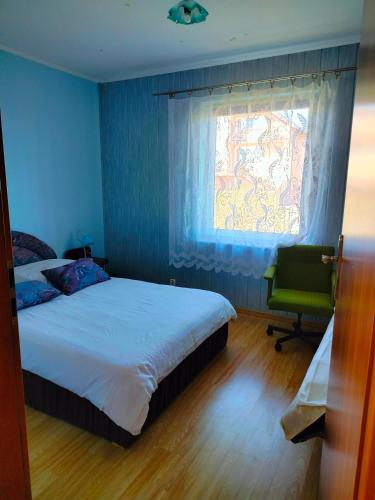 a bedroom with a bed and a window and a chair at Siedlisko Grzegorza in Leśniki