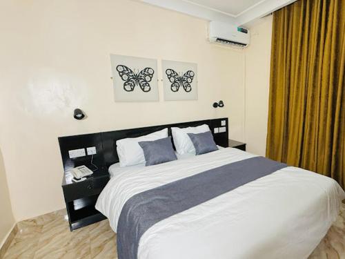 a bedroom with a bed with two butterflies on the wall at Abi's Place Benin in Benin City
