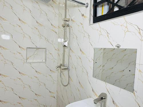 a shower in a bathroom with a toilet and a mirror at Abi's Place Benin in Benin City
