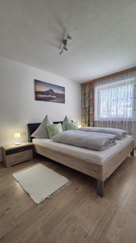 a bedroom with a large bed and a window at Ferienwohnung Sonnweber in Stanzach