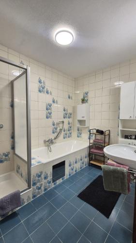 a bathroom with a tub and a shower and a sink at Ferienwohnung Sonnweber in Stanzach