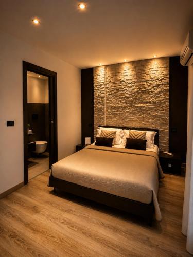 a bedroom with a large bed and a brick wall at B&B La Bouganville in Alghero