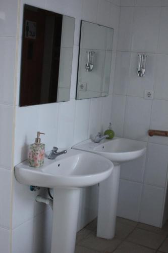 a white bathroom with two sinks and a mirror at Alojamiento El Monasterio in Almonaster la Real