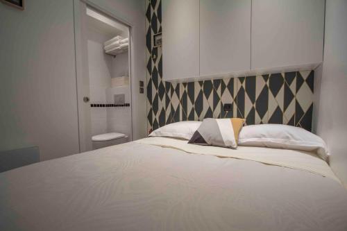 パリにあるノートル ダム パラディ ラタンのベッドルーム(白い大型ベッド、白い枕付)
