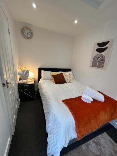 a bedroom with a bed and a clock on the wall at Self-Contained Studio with Ensuite & Private Access in Hardwicke