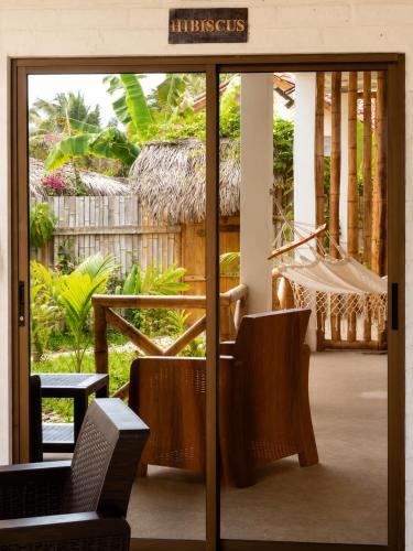 an open door to a patio with a hammock at Casita Madame - Frente al Mar con Desayuno Gourmet in Puerto López
