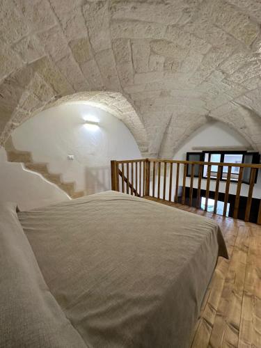 a bedroom with a bed with a stone wall at Piazza San Giorgio B&B in Serrano