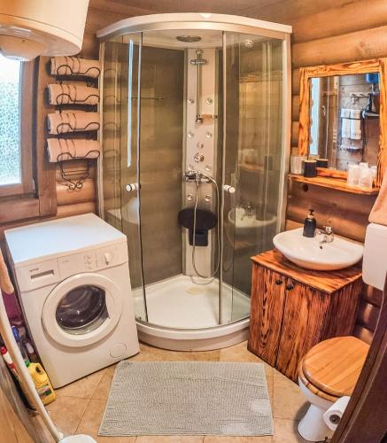 a bathroom with a shower and a washing machine at House Villa Ursus in Gerovo