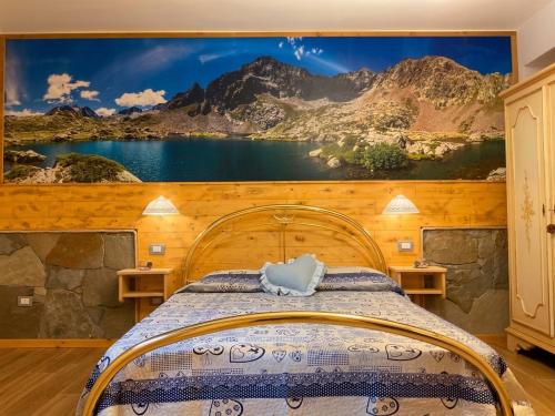 a bedroom with a bed with a painting on the wall at Cà d'Margherita and Heidi in Valdieri