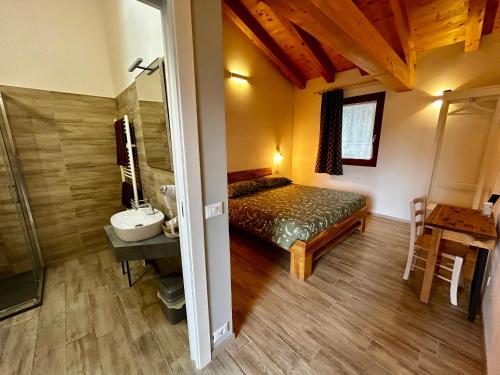 a bedroom with a bed and a sink in a room at Locanda B&B Da Nati in Arba