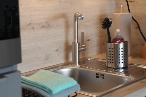 a kitchen sink with a toothbrush in a holder at Apartment Nordly in Wendtorf