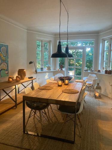 a dining room with a wooden table and chairs at La Petite Ecole in Bindslev