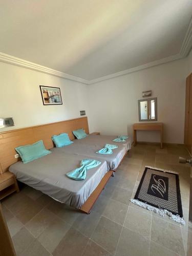 two twin beds in a room with two tables at Beachfront Apartment 105- Hotel Andalucia in Bizerte