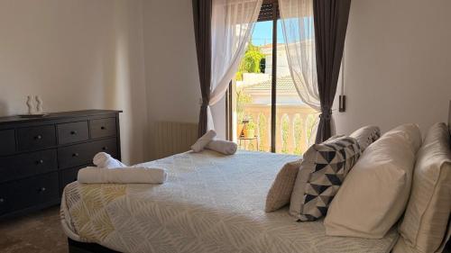 a bedroom with a bed with two pillows and a window at Casa El Jazmín in Alfacar