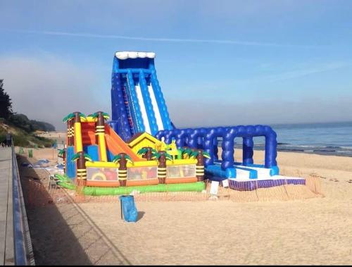 a playground on the beach with a water slide at Bursztynowe Domki in Sarbinowo
