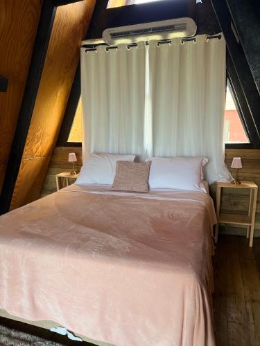a bedroom with a bed with a white canopy at Chalé Aurora - Sebollas - Paraíba do Sul in Paraíba do Sul
