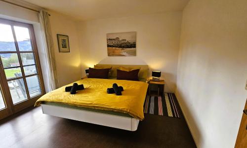a bedroom with a bed with yellow sheets and a window at Jungholz Erlebnis in Jungholz