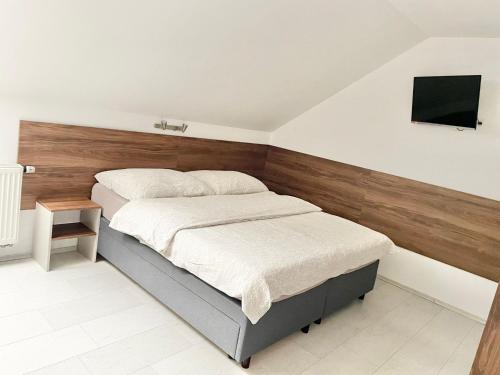 a bedroom with a bed and a tv on the wall at Apartmány Banff in Bešeňová