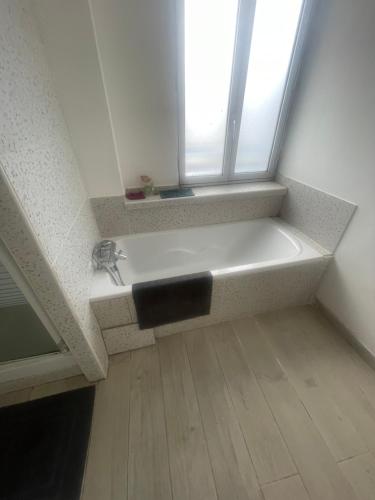 a bathroom with a white sink and a window at les chambres Carnot in Elbeuf