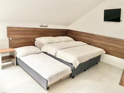 a bedroom with three beds and a flat screen tv at Apartmány Banff in Bešeňová