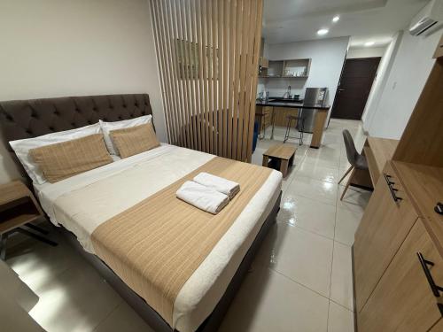 a bedroom with a bed with two towels on it at “SC Apartments” Equipetrol in Santa Cruz de la Sierra