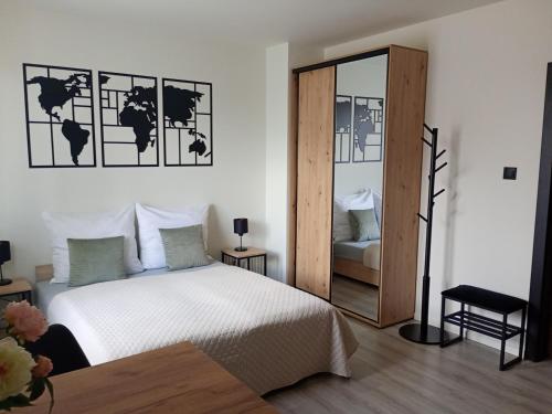 a bedroom with a white bed and a mirror at Palomino pokoje agroturystyka in Świnoujście