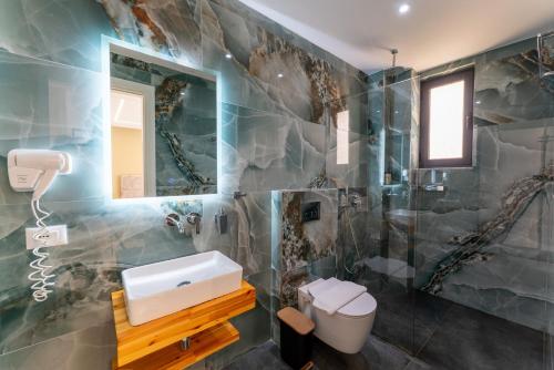 a bathroom with a sink and a mirror at Poseidon Hotel Ksamil in Ksamil