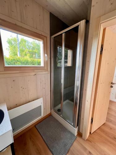 a small bathroom with a shower in a tiny house at Mokuzo Tiny Houses in Lauingen