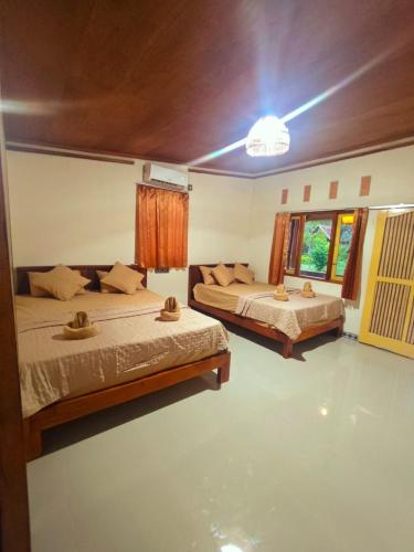 a bedroom with two beds and a window at Naicha Green in Tetebatu