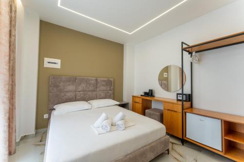 a bedroom with a bed and a mirror at Poseidon Hotel Ksamil in Ksamil