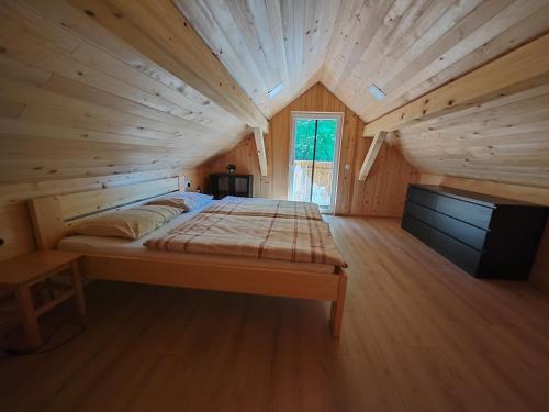 a bedroom with a bed in a wooden room at Honey house in Zgornje Gorje