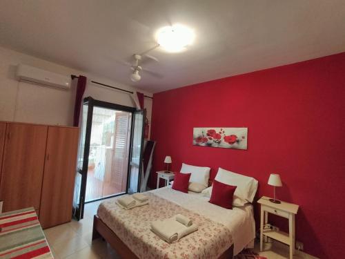 a red bedroom with a bed with a red wall at Da Rosa in Letojanni