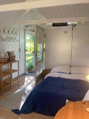 a bedroom with a bed with a blue blanket on it at La Petite Ecole in Bindslev