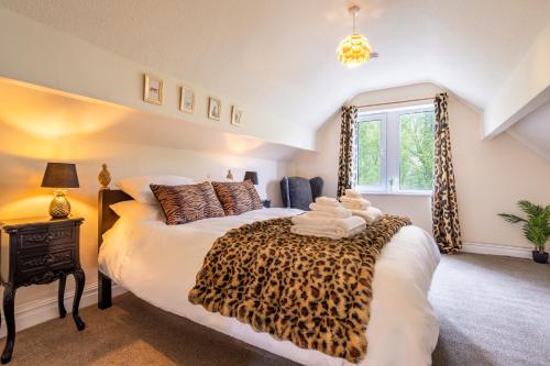a bedroom with a bed with a leopard print blanket at Lindores Bed & Breakfast in Todmorden