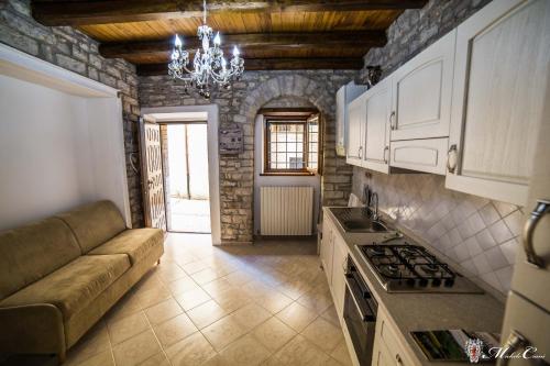 斯波萊托的住宿－Appartamento di Lucrezia，一间厨房,内设白色橱柜和沙发