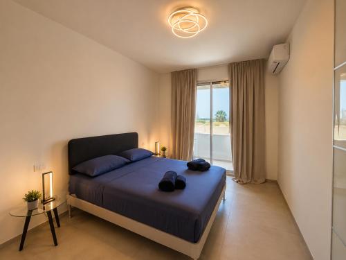 a bedroom with a bed with shoes on it at Sea & Pool Apartment in Casa Santa