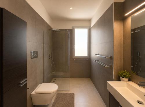 a bathroom with a toilet and a sink and a shower at Sea & Pool Apartment in Casa Santa