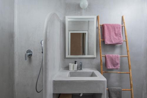 a bathroom with a sink and a mirror at Rosys Little Village in Skala