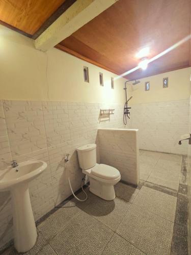 a bathroom with a toilet and a sink at Naicha Green in Tetebatu