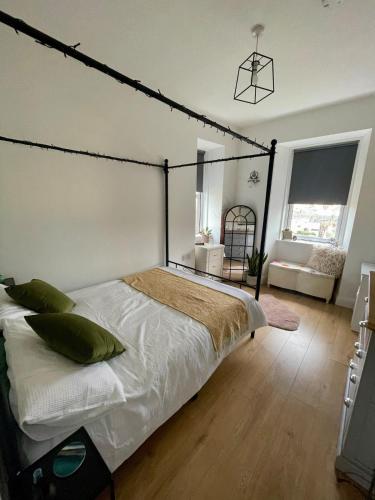 a bedroom with a large bed with a black frame at The Nook Dunblane in Dunblane