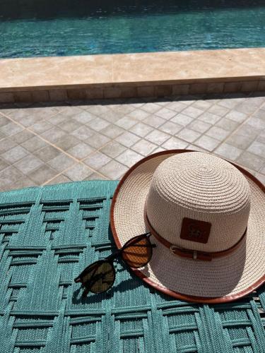 a straw hat sitting on a mat next to a swimming pool at Dar Joud Kaouki in Sidi Kaouki