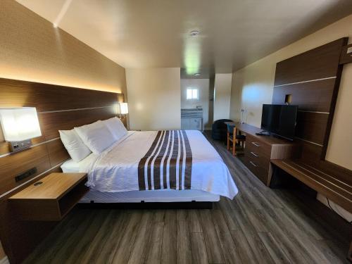a hotel room with a bed and a flat screen tv at Knights Inn Lindsay in Lindsay