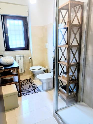 a bathroom with a toilet and a glass shower at Cristine's House in Marino