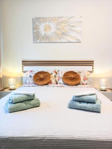 a white bed with three pillows on it at Cristine's House in Marino