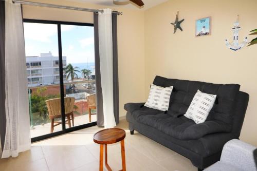 a living room with a couch and a view of the ocean at Beautiful apartment just 1 block from the beach. in Mazatlán