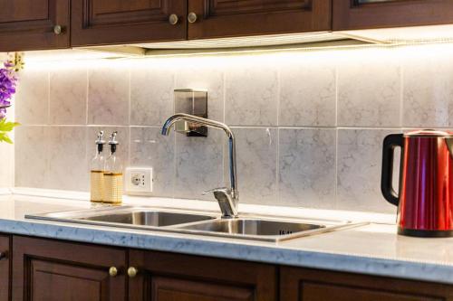 a kitchen sink with a red appliance on a counter at Beachfront Central Apartments in Durrës