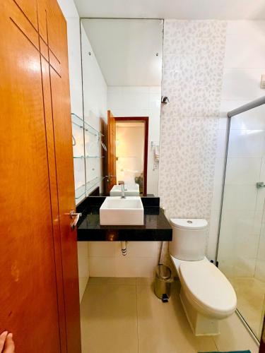 a bathroom with a sink and a toilet and a mirror at Apartamento de 2 Quartos no Centro in Imperatriz